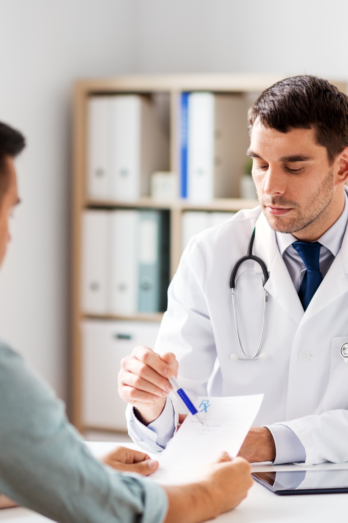 Arzt bespricht Unterlagen mit einem Patienten